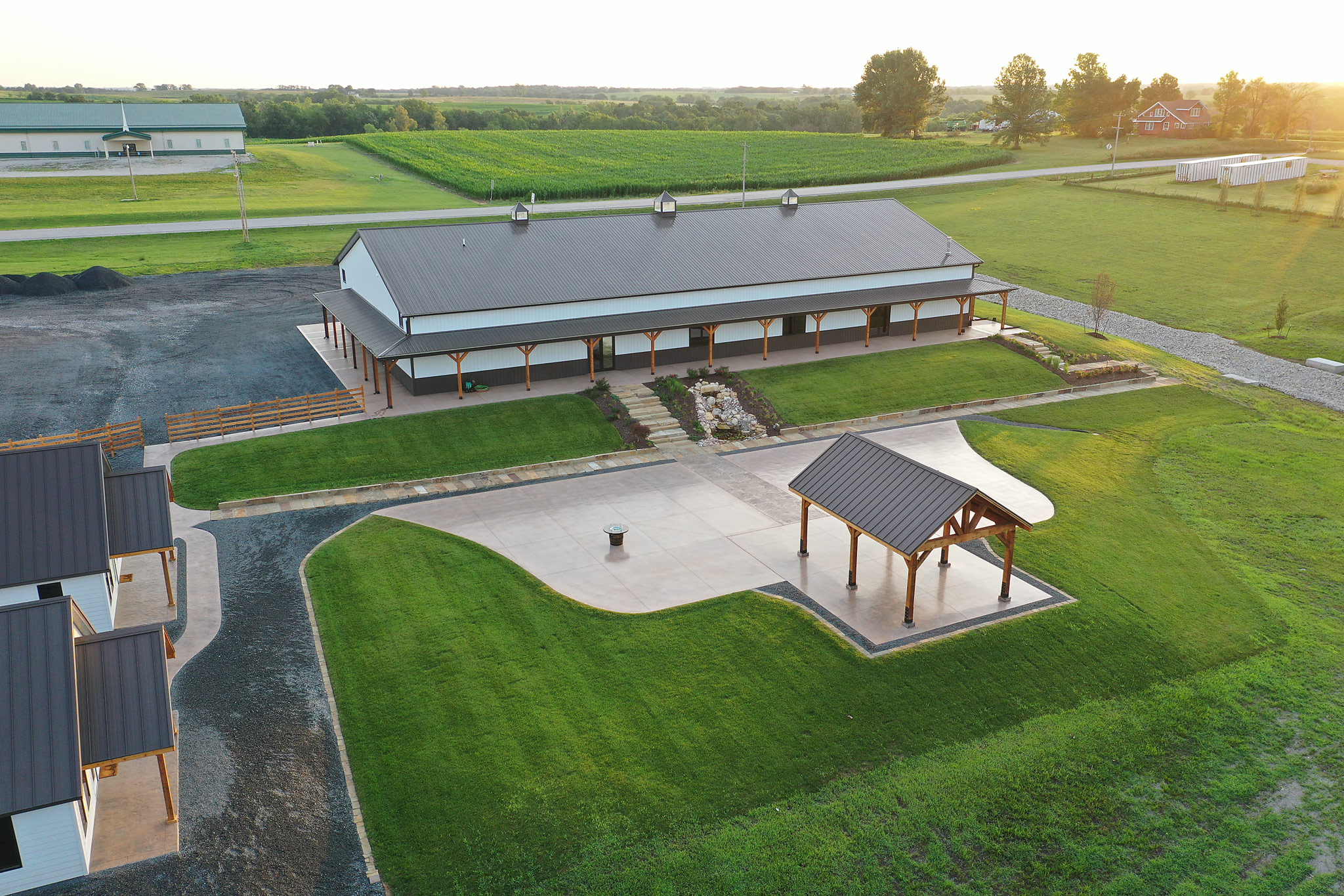 Aerial photo of The VeNue Event Space showing the outdoor Courtyard with covered pavilion. There is a corn field in the distance.