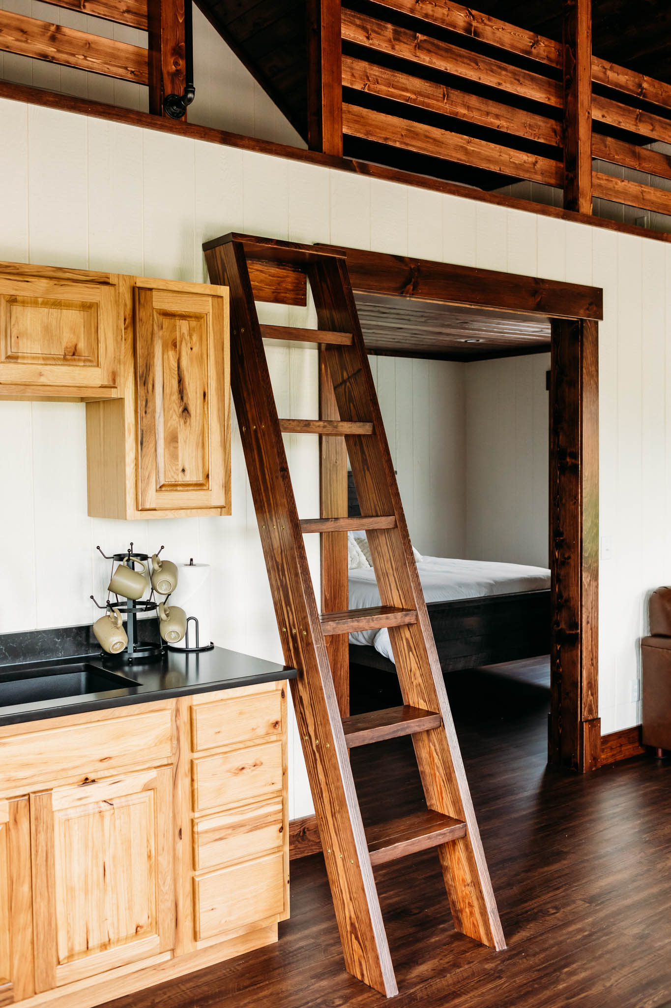 A view of the Villas at The VeNue's ladder leading to the sleeping loft, part of the kitchenette with the bedroom in the background