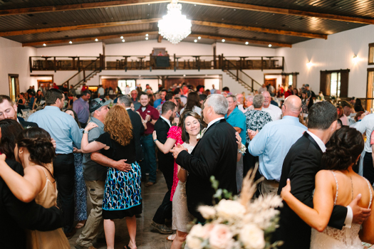 A large group of people dancing on the dance floor of The VeNue Event Space. Photography copyright Alicia Castañeda Photography.