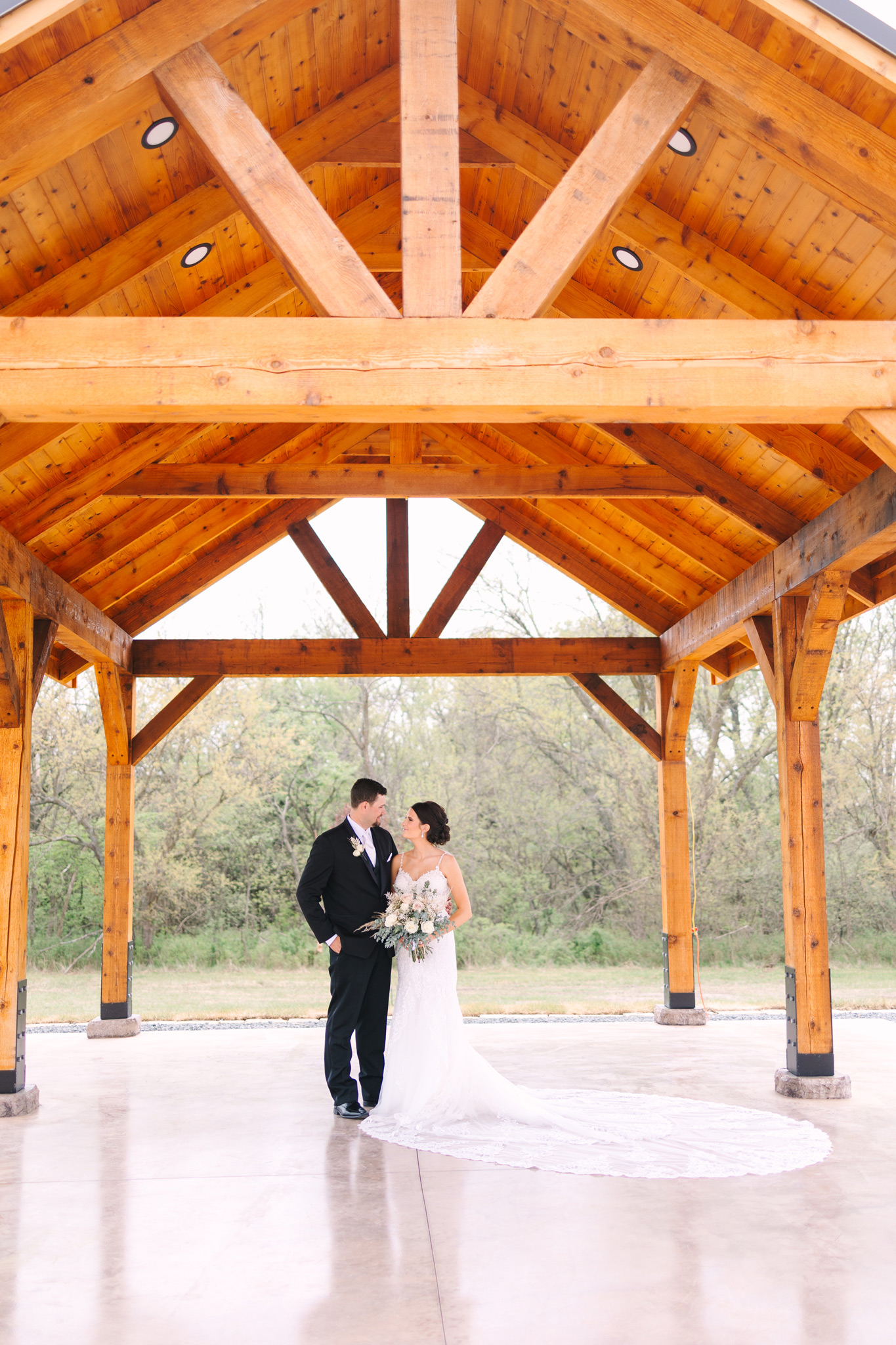 A bride and groom embrace and look at each other under the Pavilion in the Courtyard at The VeNue Event Space