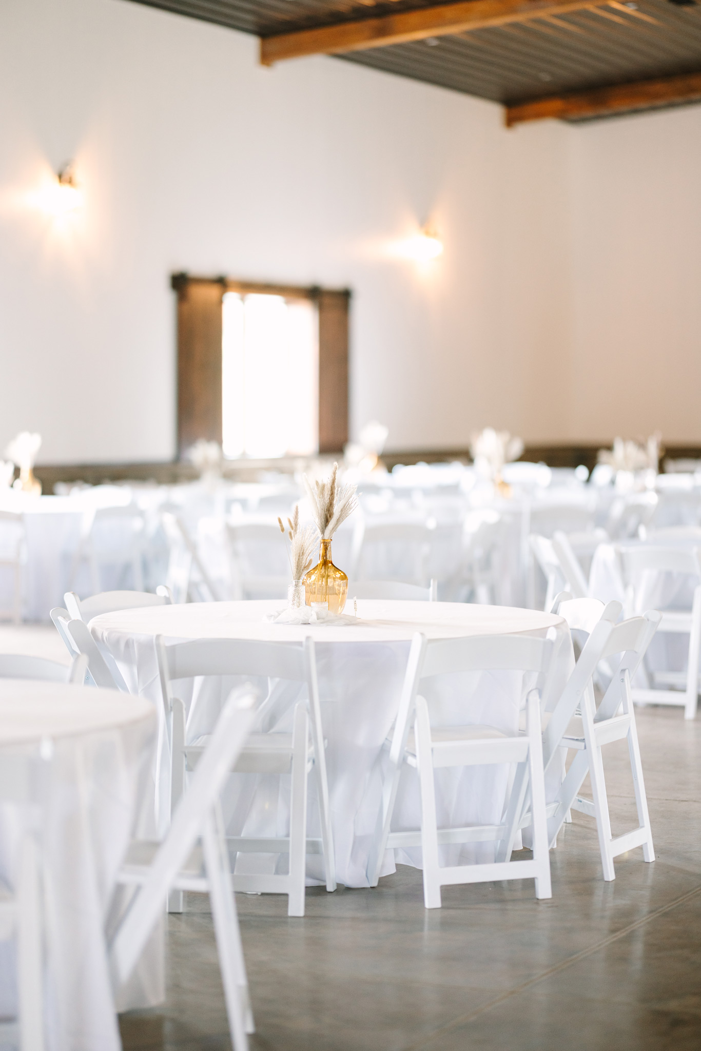 Tables at The VeNue Event Space set up with white linens and ready for a wedding